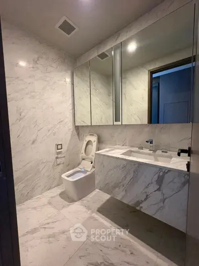 Luxurious marble bathroom with modern fixtures and large mirror