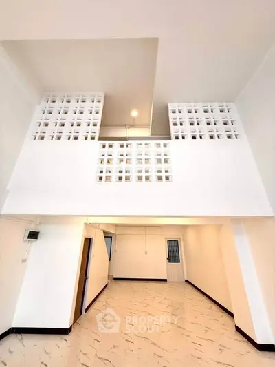 Spacious modern interior with high ceilings and unique architectural design, perfect for stylish living.