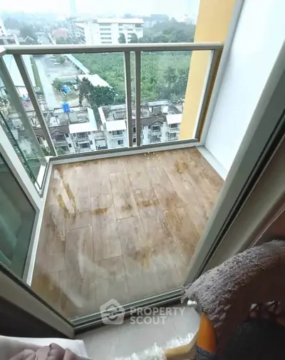 Charming balcony with glass railing offering a serene view of the neighborhood.