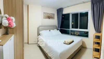 Cozy bedroom with large window and modern decor in a stylish apartment.