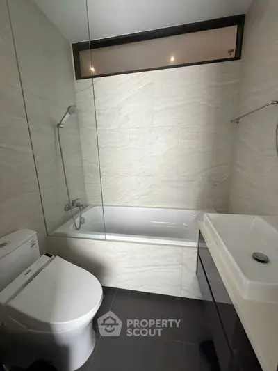 Modern bathroom with sleek design, featuring a bathtub and contemporary fixtures.