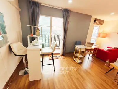 Modern living room with wooden flooring, stylish furniture, and a balcony view.