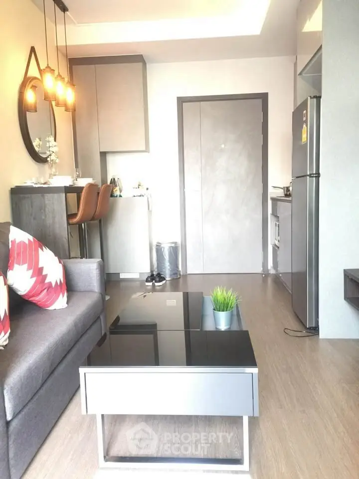 Modern living room with stylish decor and compact kitchen area.