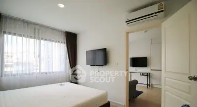 Modern bedroom with wall-mounted TV and air conditioning in bright apartment