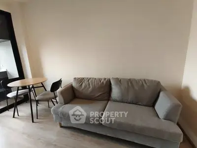 Cozy living room with modern gray sofa and dining table set