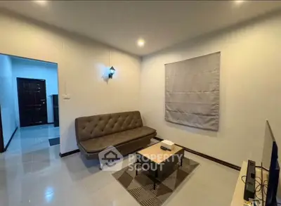 Cozy living room with modern sofa and TV, perfect for relaxation.