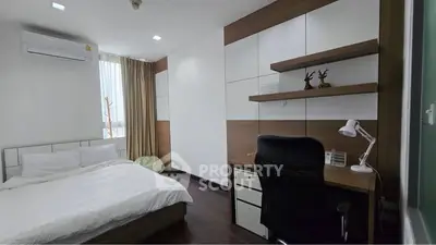 Modern bedroom with study area, featuring sleek furniture and natural light.