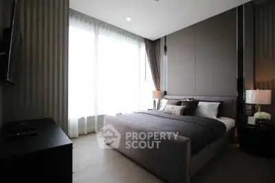 Luxurious modern bedroom with elegant decor and large windows for natural light.