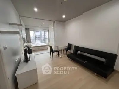 Modern living room with sleek furniture and city view in a high-rise apartment.