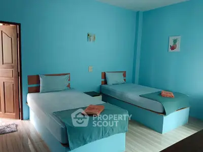 Bright blue bedroom with twin beds and modern decor