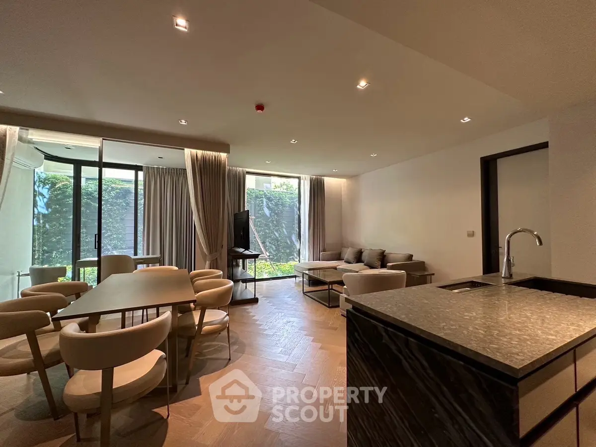 Spacious modern living room with open kitchen and garden view