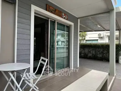Charming modern patio with sliding glass door and cozy seating area, perfect for relaxation and outdoor enjoyment.