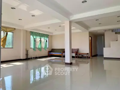 Spacious living room with large windows and modern design, perfect for family gatherings.