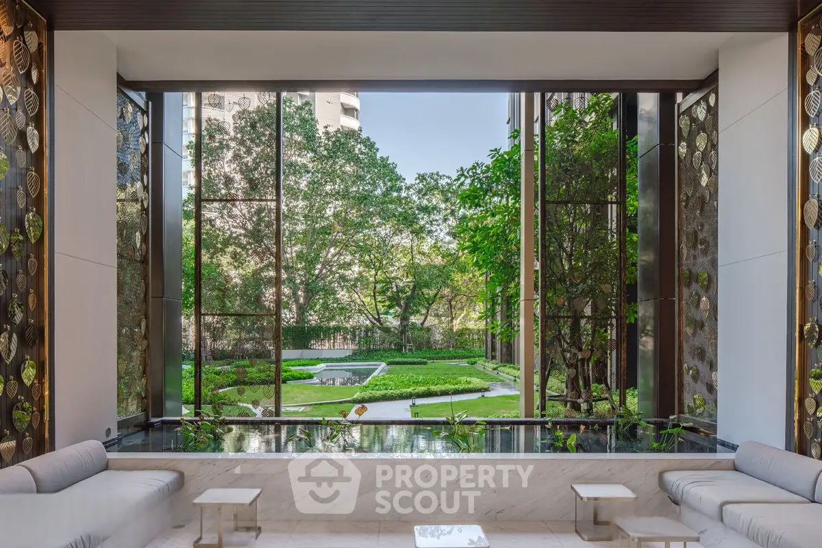 Luxurious building lobby with stunning garden view and elegant seating area.