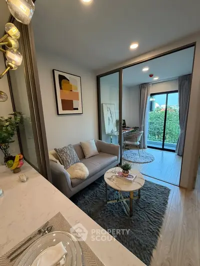 Modern living room with stylish decor and balcony view, perfect for cozy urban living.