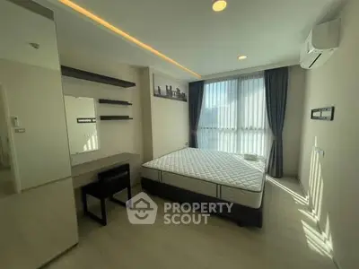 Modern bedroom with natural light, minimalist decor, and air conditioning in a stylish apartment.