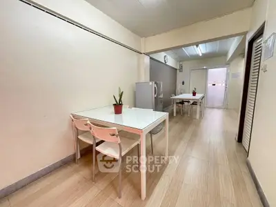 Spacious dining area with modern furniture and wooden flooring in a cozy apartment.