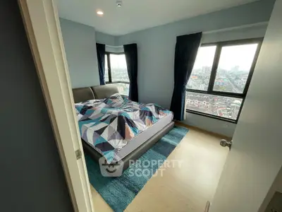 Modern bedroom with city view, featuring stylish decor and large windows.