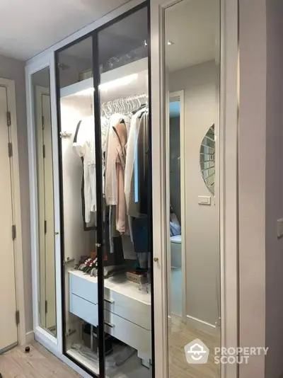 Modern bedroom with sleek mirrored wardrobe and organized interior storage