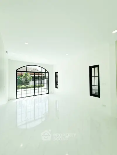 Spacious and bright living room with large windows and elegant flooring