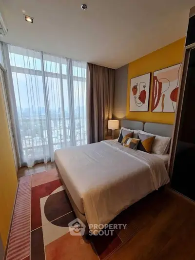 Modern bedroom with large window and stylish decor in high-rise apartment.