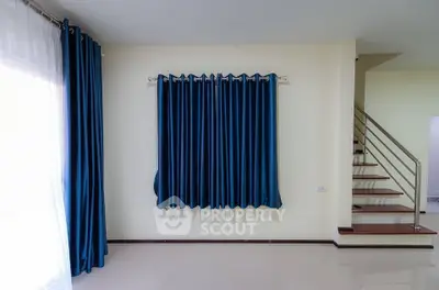 Modern interior with blue curtains and staircase in a bright living space