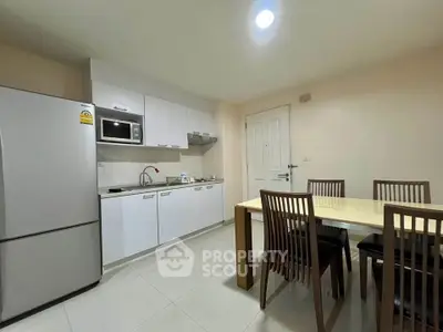 Modern kitchen with dining area featuring sleek cabinetry and stainless steel appliances.