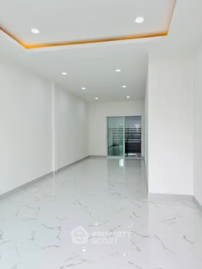 Spacious modern interior with marble flooring and recessed lighting, ideal for versatile living space.