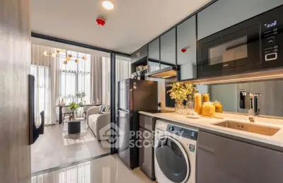 Modern kitchen with sleek appliances and open layout leading to stylish living room