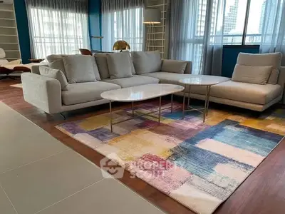 Spacious modern living room with colorful rug and elegant furniture.