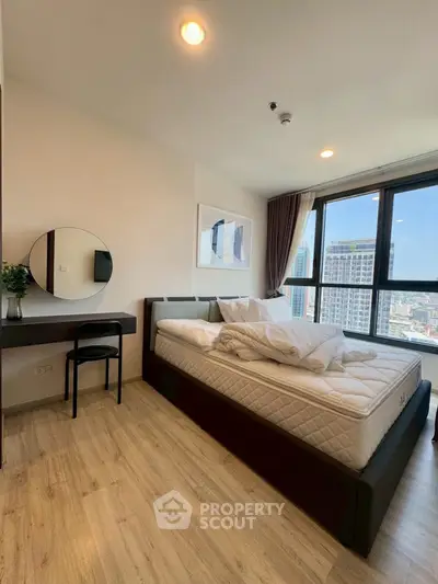 Modern bedroom with city view, featuring stylish decor and natural light.