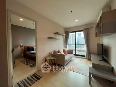 Modern living room with city view, cozy sofa, and stylish decor in a high-rise apartment.