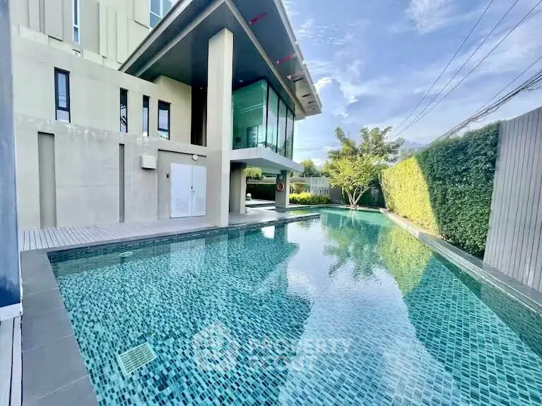 Stunning modern home with luxurious private pool and lush garden view.