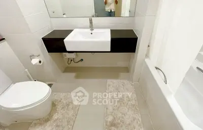 Modern bathroom with sleek fixtures and bathtub in a contemporary home.