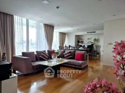 Spacious living room with elegant decor and city view, featuring a large sofa and dining area.