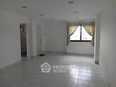 Spacious unfurnished room with tiled flooring and large window