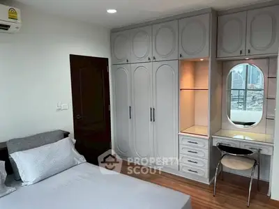 Spacious bedroom with built-in wardrobe and city view, perfect for urban living.