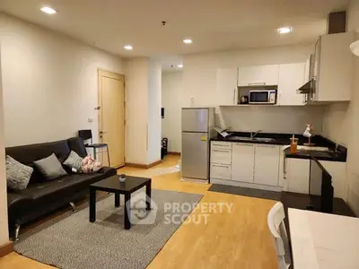 Modern open-layout living room and kitchen with sleek furniture and appliances