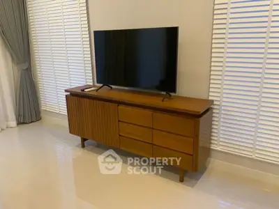 Modern living room with sleek TV stand and large flat-screen TV.