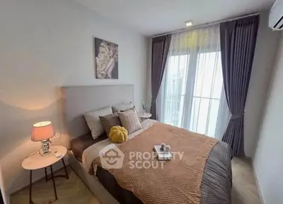 Cozy bedroom with modern decor and large window for natural light.