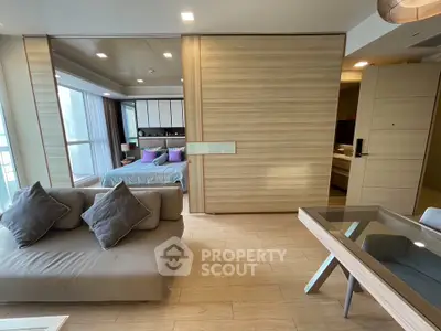 Modern open-plan living room with stylish decor and cozy bedroom area