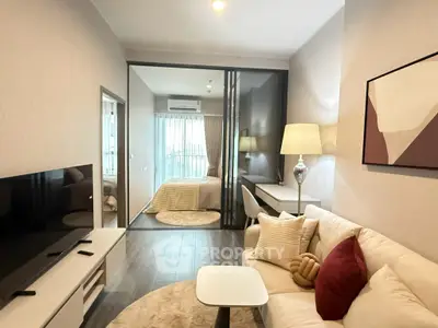 Modern living room with cozy sofa, stylish decor, and a view into a chic bedroom.