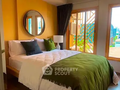Cozy bedroom with modern decor and large windows offering natural light and a vibrant view.