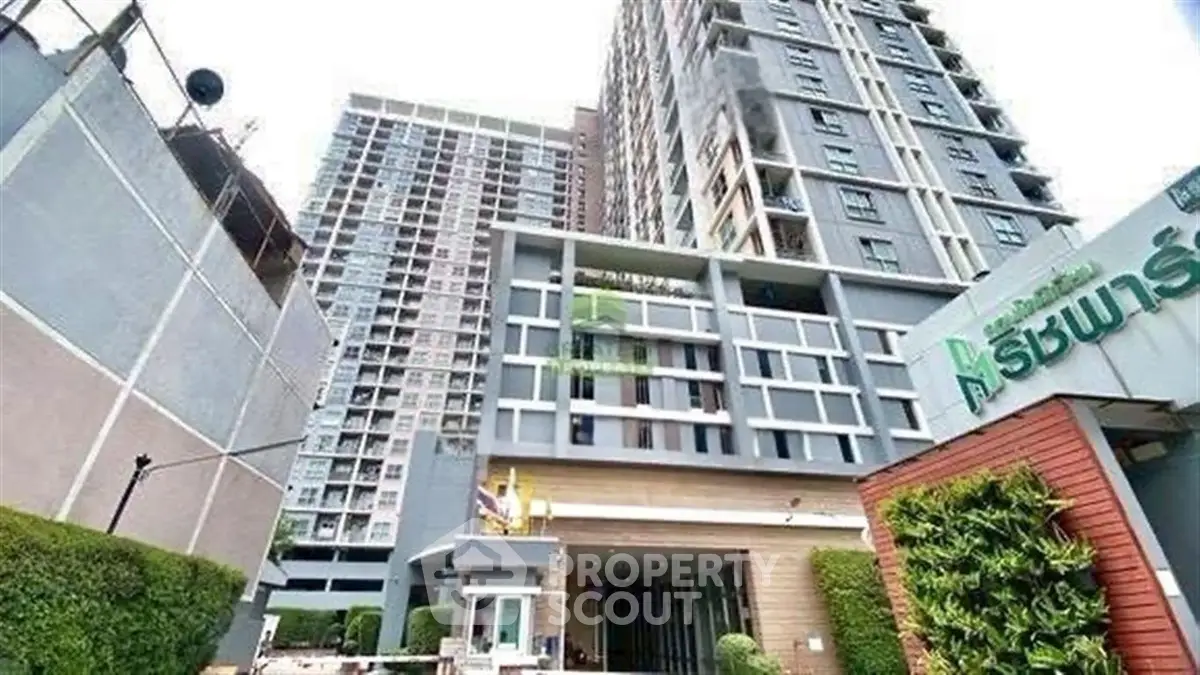 Modern high-rise condominium with lush greenery and stylish entrance