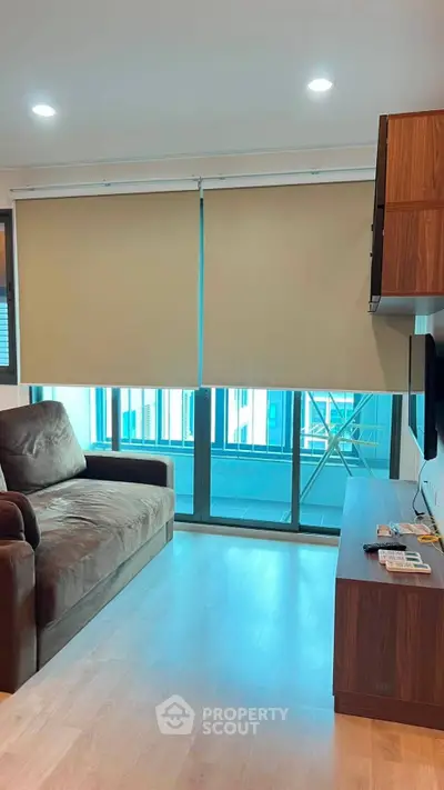 Modern living room with sleek furniture and large windows offering natural light.