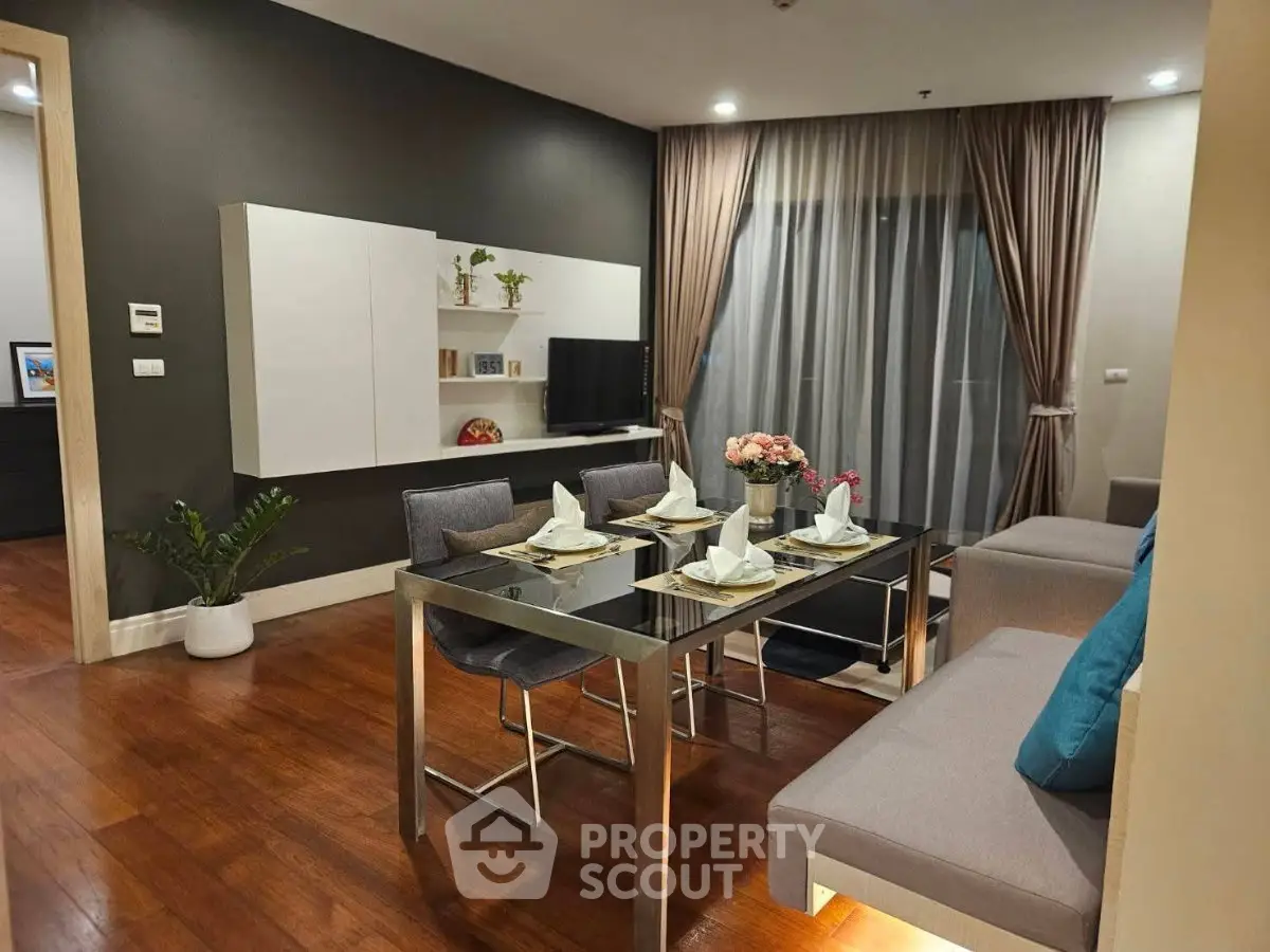 Modern living room with dining area, sleek furniture, and elegant decor in a stylish apartment.
