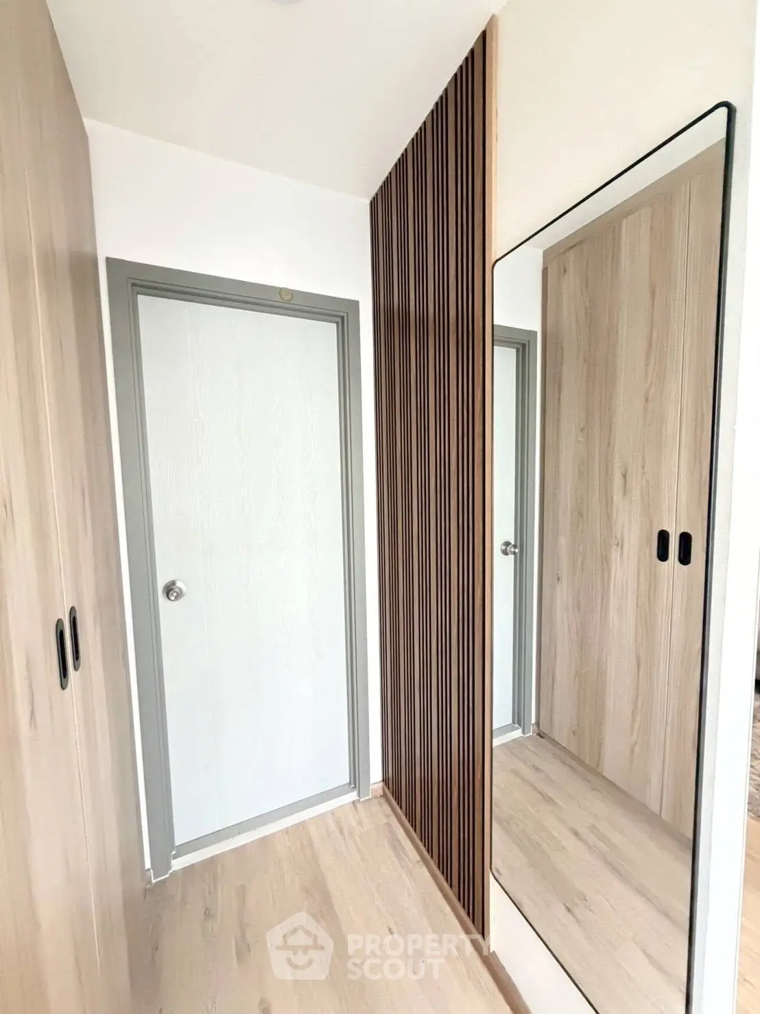 Modern hallway with sleek wooden paneling and full-length mirror