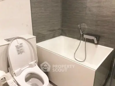 Modern bathroom with sleek bathtub and toilet in contemporary design.