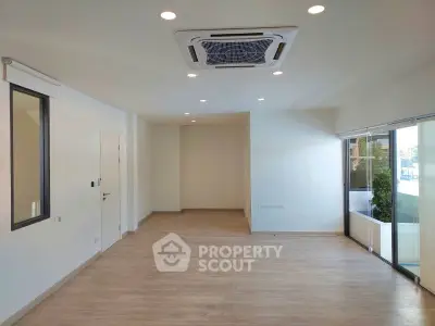 Spacious modern living room with large windows and sleek air conditioning unit.