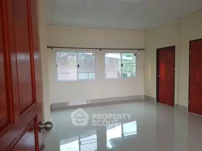 Spacious empty room with glossy tiled floor and large windows